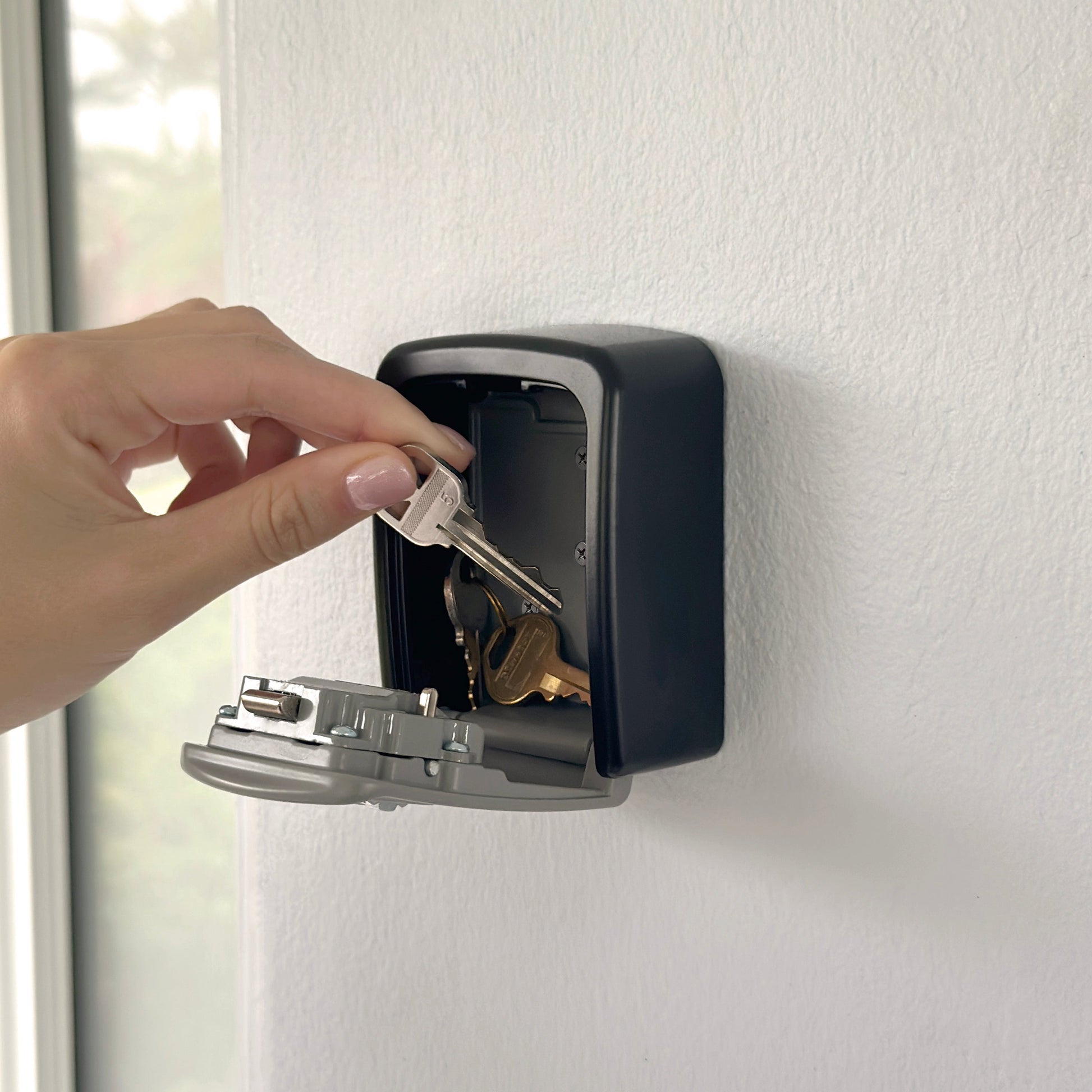 Keys stored inside the wall-mounted combination lock box